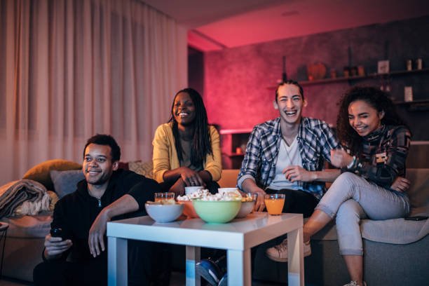 Excited family watching live sports on a large TV in a modern living room